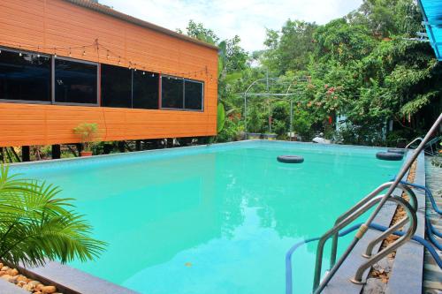 a large swimming pool next to a building at Hideaway Village Homestay in Xuân Sơn