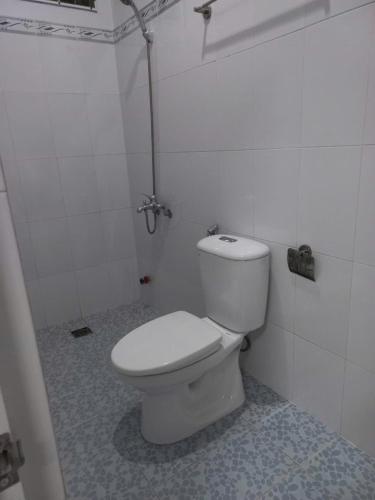 a bathroom with a white toilet in a stall at Nhà nghỉ KIM VÀNG in Phú Quốc