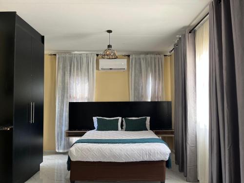 a bedroom with a large bed with green pillows at Sedudu Turn Cottages in Maun