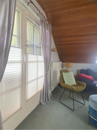 a living room with a window and a chair at Ferienwohnung Vogelsang in Undeloh