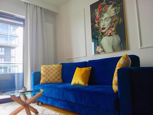 a blue couch with yellow pillows in a living room at Katowice Spodek in Katowice