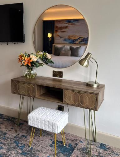 a bedroom with a table with a mirror and a bed at Trouville Bournemouth - OCEANA COLLECTION in Bournemouth