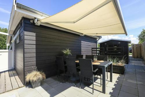 a patio with a table and a large umbrella at Holiday Home With A Direct Path To The Sea in Korsør
