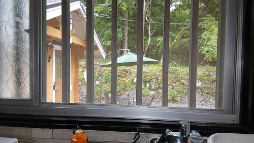 a window in a kitchen with a view of a yard at こや・かやき in Yufu