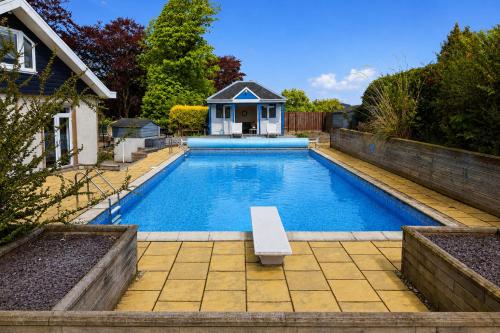 a swimming pool with a bench in a backyard at Five Marches - Poolside Stays with Stunning Views in Angus