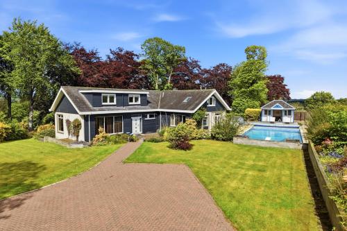 a house with a swimming pool in the yard at Five Marches - Poolside Stays with Stunning Views in Angus