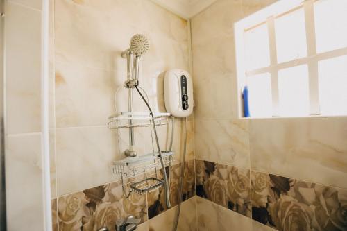 a shower with a blow dryer in a bathroom at Rouse precious haven in Nakuru