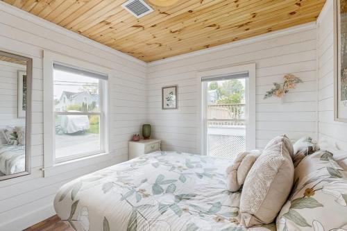 a bedroom with a bed and two windows at Salt & Petal in Old Orchard Beach