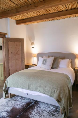 a bedroom with a large bed with a wooden ceiling at Vineyard Cottage at Bosman Wines in Wellington