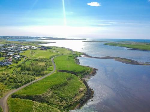 eine Luftaufnahme eines Golfplatzes und des Ozeans in der Unterkunft Hotel Laxnes in Mosfellsbær
