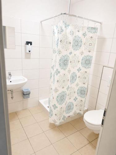 a bathroom with a toilet and a shower curtain at ELO STAY Nordheide 24h Check-in, Free Parking and WiFi in Buchholz in der Nordheide