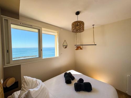 a bedroom with a bed with a view of the ocean at La Tour Somma in Valras-Plage