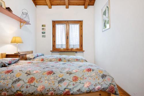 a bedroom with a bed with a colorful comforter at Casa Pòlse in Baselga di Pinè