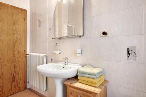 a bathroom with a sink and a mirror and towels at Casa Pòlse in Baselga di Pinè