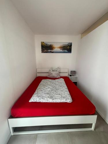 a bedroom with a red bed in a white room at Casa Nova Apartment in Geislingen an der Steige