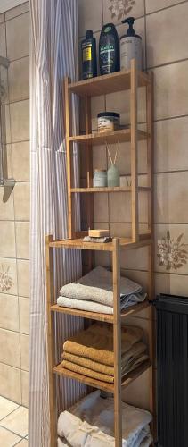 a wooden shelf with towels on it in a bathroom at Cozy Garden Glamping in Svendborg