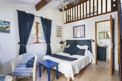 a bedroom with a bed and a chair at Gite Insolite Mas Boutet in Argelès-sur-Mer