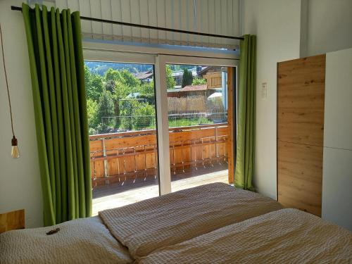 a bedroom with a bed and a large window at Bergzauber Ofterschwang in Ofterschwang