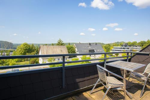 a patio with two chairs and a table on a balcony at Welcome in - Studio 57-S mit Balkon, 200 m von der Skipiste entfernt in Winterberg