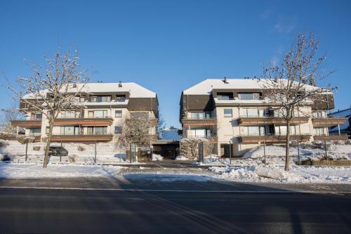 an apartment building with snow in front of a street at Welcome in - Studio 57-S mit Balkon, 200 m von der Skipiste entfernt in Winterberg