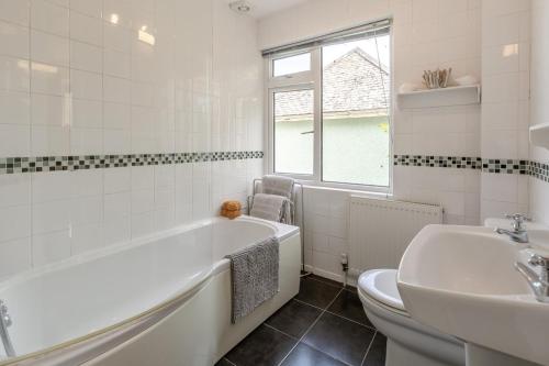 a bathroom with a tub and a toilet and a sink at 2 Bed in Looe oc-l30026 in Looe