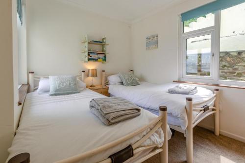 two twin beds in a room with a window at 2 Bed in Looe oc-l30026 in Looe