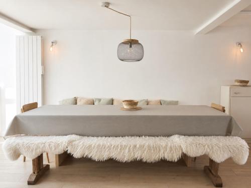 a bedroom with a large bed with a white wall at La Maison Harmony in Beuvron-en-Auge