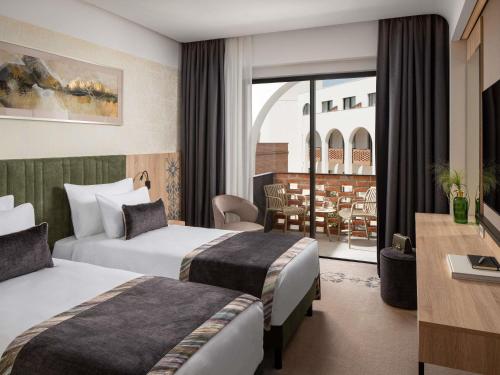 a hotel room with two beds and a balcony at Mercure Conacul Cozieni in Bucharest