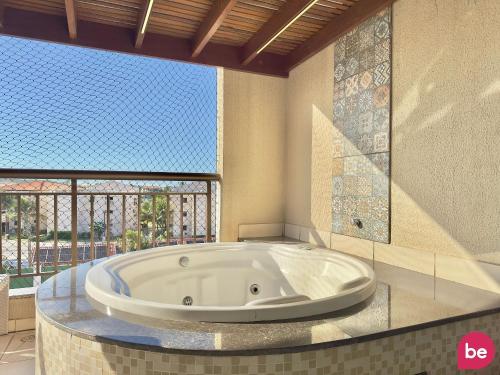 a large tub in a bathroom with a large window at Condomínio Mediterranee Residence por Be My Guest in Aquiraz