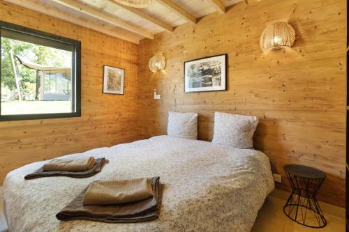 a bedroom with a bed in a wooden wall at Le Pech Eternel-Lodge Spa Tilleuls in Sarlat-la-Canéda