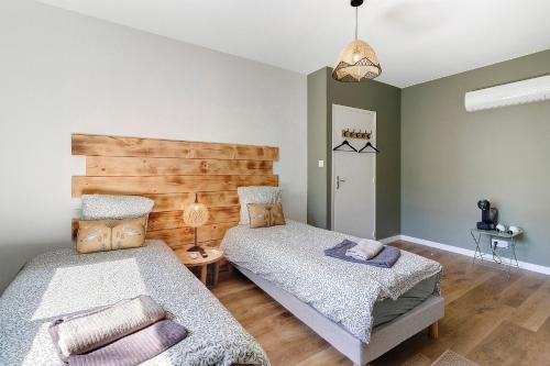 a bedroom with two beds and a wooden headboard at Le Pech Eternel - La Truffière in Sarlat-la-Canéda