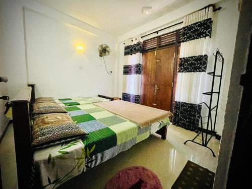 a bedroom with a bed and a window with curtains at Devil mountain guest in Kalupahana