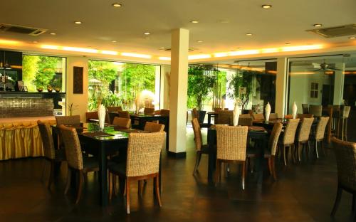 a dining room with a table and chairs at Palm Grove Resort, Pattaya in Na Jomtien