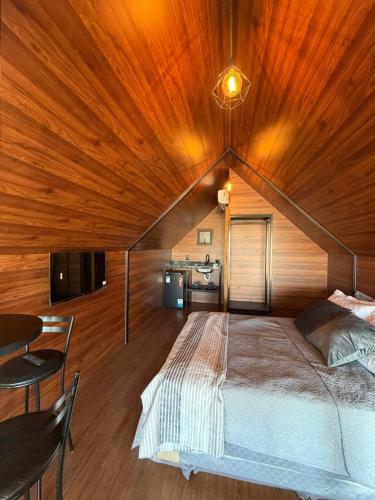 a bedroom with a large bed with a wooden ceiling at Alta Vista Cabanas in Garibaldi