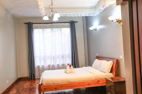 a bedroom with a bed and a window at Legacy Homes in Nairobi