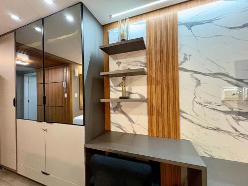 a bathroom with a counter and a marble wall at Unity Cabo Branco in Penha