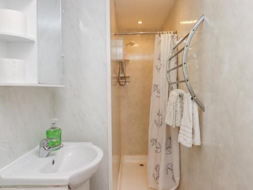 a bathroom with a shower curtain and a sink at Apartment 2 in Torquay