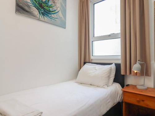 a bedroom with a white bed and a window at Apartment 2 in Torquay