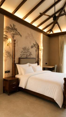 a bedroom with a large white bed with palm trees on the wall at La Damai in Aldūr