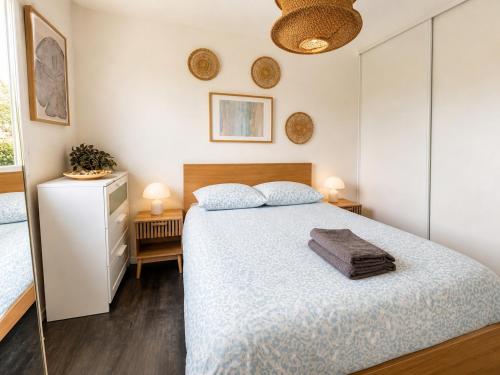 a bedroom with a large bed and two lamps at Charmant T2 Bordeaux Proche tram & centre-ville in Bruges