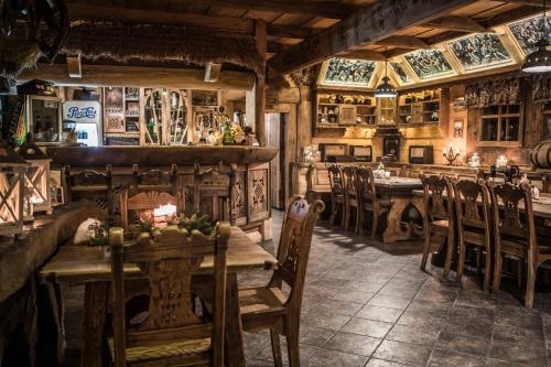 Góralski Dwór في كوشتيليسكا: مطعم بطاولات وكراسي خشبية في الغرفة