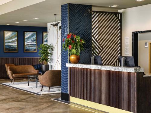 a lobby with a reception counter and chairs at Mercure Paignton Hotel in Paignton