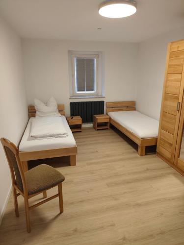 a room with two beds and a chair in it at Hof Grübler in Klipphausen