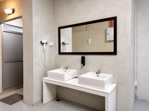 a bathroom with two white sinks and a mirror at Astrid Lofts in Ipoh