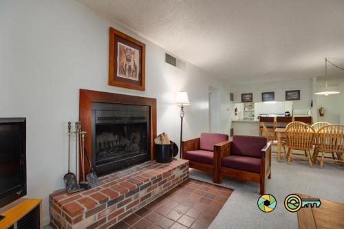 a living room with a fireplace and a couch and chairs at Senedo Springs Condo #2-202 in Basye