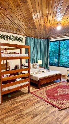a bedroom with two bunk beds and a wooden ceiling at Umda Hotel in Nathia Gali