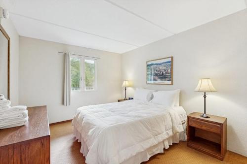 a white bedroom with a bed and a window at Seasons 200 in Warren
