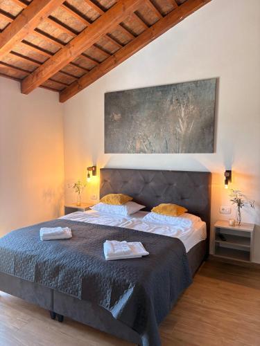 a bedroom with a large bed and a painting on the wall at Villa Francesca with Private Pool & Designer Interior in Kaštel