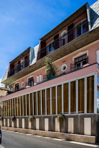 a pink building with windows on the side of a street at Hotel Cesari in Rimini