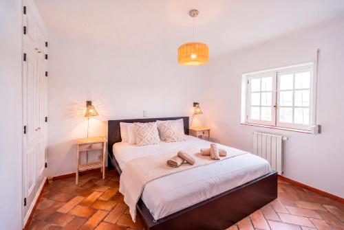 a bedroom with a bed with two shoes on it at Casa da Figueira in Ericeira